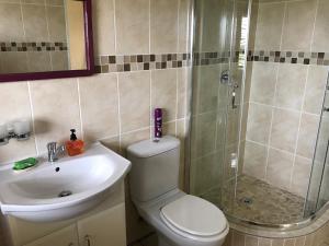 a bathroom with a shower and a toilet and a sink at Sandy Bottoms in Jeffreys Bay +14 photos
