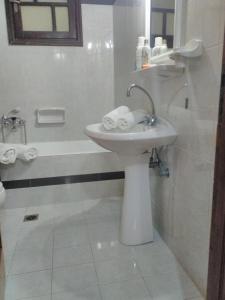 a white bathroom with a sink and a bath tub at Minies Beach Villas in Minia +45 photos