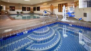 a swimming pool with blue tiles in a building at Best Western Plus Northwind Inn & Suites in Tigard