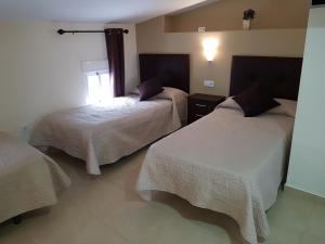 Łóżko lub łóżka w pokoju w obiekcie Hostal Málaga