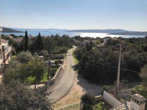 a winding road in a town with trees and water at Apartments Antolkovic in Ugljan