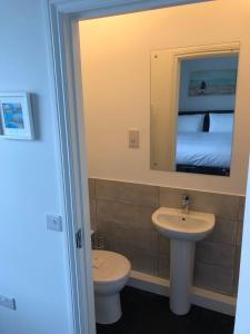 a bathroom with a sink and a toilet and a mirror at The Ships Quarters in Eyemouth