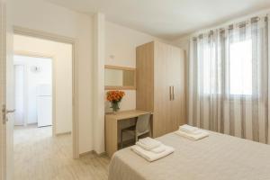a bedroom with a bed and a desk with two towels at Case Vacanza appartamenti Trinacria in San Vito lo Capo