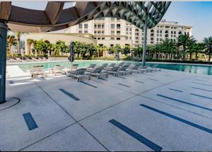 a swimming pool with lounge chairs and a building at Mayfair Serviced Apartment - D1 Tower in Dubai