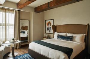 a bedroom with a large bed and a mirror at Hotel Figueroa, Unbound Collection by Hyatt in Los Angeles +37 photos