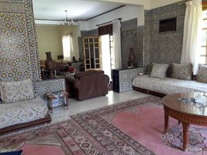 a living room with two couches and a table at Villa Tazi in Meknès