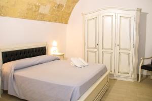 a bedroom with a bed with a white bedspread at Palazzo Piccioli in Gallipoli