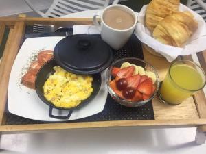 a breakfast tray with eggs and fruit and a cup of coffee at Hotel Living 55 in Bogotá