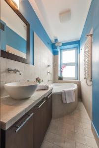 La salle de bains est pourvue d'un lavabo blanc, d'une baignoire et d'une chambre. dans l'établissement Dworzec Centralny P&O Serviced Apartments, à Varsovie