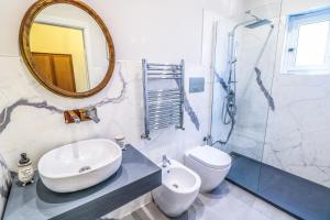 a bathroom with a sink and a toilet and a mirror at Scognamiglio Suites in Ercolano