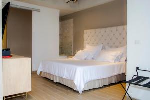 a bedroom with a large bed with white sheets and pillows at Country International Hotel in Barranquilla