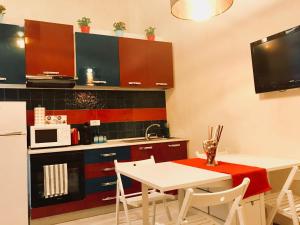 フィレンツェにあるLeonardo's Signoria Suiteのキッチン(白いテーブル、電子レンジ付)