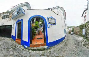 un pequeño edificio azul y blanco en una calle en Posada Joan Sebastian en Taxco de Alarcón