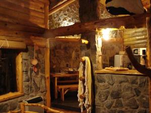 una cocina en una cabaña de madera con una pared de piedra en Portal Del Tala Centro Ecoturístico en Alpa Corral
