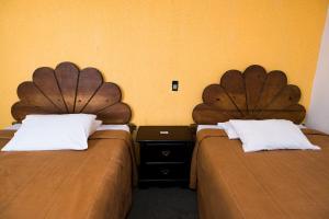 Hotel María Elena في ولاية دورانغو: سريرين يجلسون بجانب بعض في غرفة