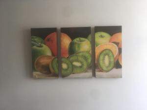 three paintings of apples and fruit on a wall at Conjunto Ballena Townhouses in Puerto Peñasco