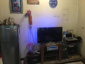 a living room with a television and a refrigerator at Guesthouse Cavite in Dasmariñas
