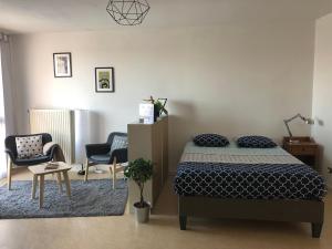 1 dormitorio con 1 cama, 2 sillas y mesa en Woézon Na Mi en Lyon