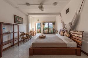 ein Schlafzimmer mit einem großen Bett und einem Tisch und Stühlen in der Unterkunft BABA Guesthouse in Don Det