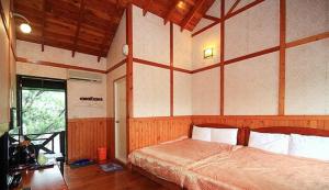 Posteľ alebo postele v izbe v ubytovaní 大湖底木屋民宿