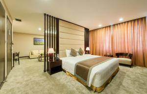 Cette chambre comprend un grand lit et un canapé. dans l'établissement Muong Thanh Hanoi Centre Hotel, à Hanoï