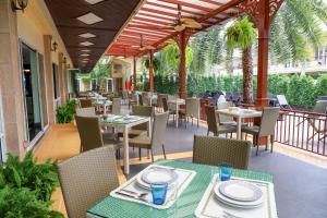 a restaurant with tables and chairs on a patio at Golden Sea Pattaya - SHA Extra Plus in Pattaya Central