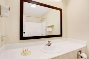 y baño con lavabo blanco y espejo. en Days Inn & Suites by Wyndham Ridgeland, en Ridgeland