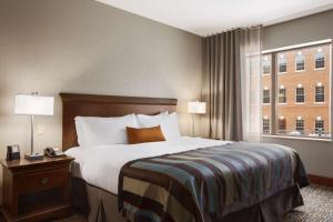 a hotel room with a bed and a window at Wingate by Wyndham Sylvania-Toledo in Sylvania
