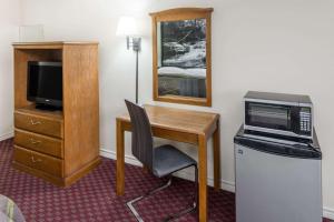 a room with a desk with a microwave and a television at Super 8 by Wyndham Hope in Hope