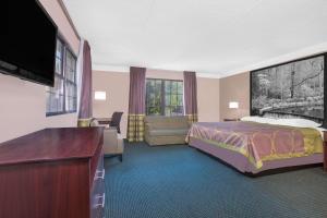 a hotel room with a bed and a flat screen tv at Super 8 by Wyndham Austell/Six Flags in Austell