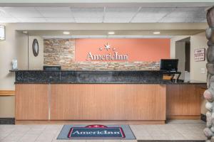 an entrance to a american inn with a sign on a counter at AmericInn by Wyndham Bismarck in Bismarck