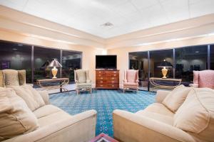 a large living room with couches and a flat screen tv at Days Inn by Wyndham Metter in Metter