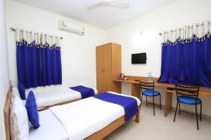 1 dormitorio con 2 camas y escritorio con ordenador en Arra Suites kempegowda Airport Hotel, en Devanhalli