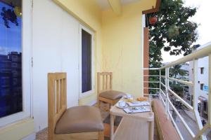 balcone con tavolo e sedie. di Arra Suites kempegowda Airport Hotel a Devanhalli