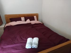 a bed with two pairs of white slippers on it at Hiltje - Nice to stay in Dordrecht