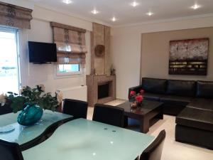 a living room with a couch and a table at Green House in Nea Peramos