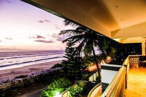a view of the beach from the balcony of a house at Sunfun Beach House in Kannur