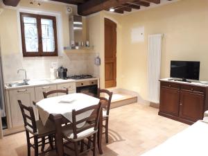 a kitchen with a table and chairs and a sink at La Corte Antica in Pienza +32 photos