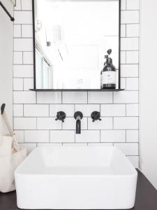 a white bathroom with a sink and a mirror at nid NAMBA Station House in Osaka