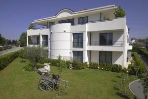 a white building with a garden in front of it at Hôtel Les Muses in Annecy