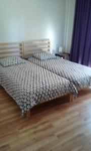 a bed in a bedroom with a wooden floor at Apartment Pinia in Poreč