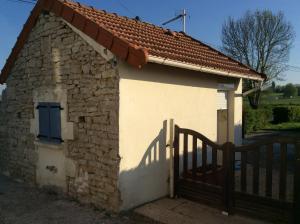 un petit bâtiment en pierre avec un portail et une clôture dans l'établissement STUDIO 11m2, à Magny-Cours