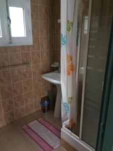 a bathroom with a shower curtain and a sink at chez mamie in Les Avirons
