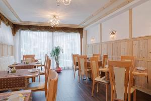 a restaurant with wooden tables and chairs and a window at Hotel Leitner in Mühlbach