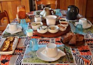 una mesa con platos y tazas y comida en ella en Une Chambre D'Hote Yvetot, en Yvetot