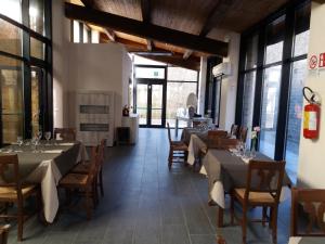 una sala da pranzo con tavoli, sedie e finestre di ostello ortensi a Farnese