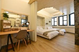 een slaapkamer met een groot bed en een bureau bij Slowly Space in Tainan