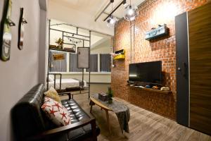 uma sala de estar com um sofá e uma parede de tijolos em Slowly Space em Tainan