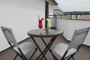 a small table with two drinks on a balcony at Real Caparica Hotel in Costa da Caparica