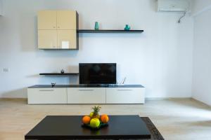 a living room with a television and a table with fruit at Alexander Apartment Mamaia in Mamaia